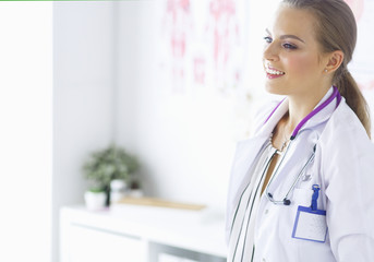 Smiling female doctor with a medical stethoscope in uniform standing