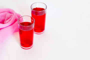 Fruit and berry red juice in glasses on a white background. Fresh and cold summer drink.