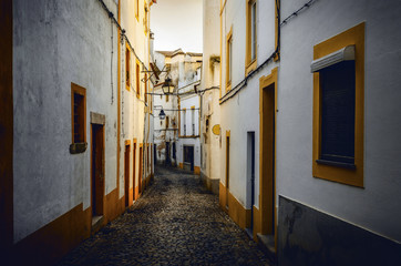 Fototapeta na wymiar Sunset in the narrow alleys of Evora, main city of the Alentejo region in Portugal, famous for its traditional white and yellow houses