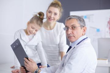 Fototapeta premium Little girl with her mother at a doctor on consultation