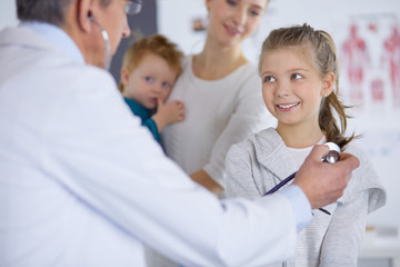 Obraz premium Girl and doctor with stethoscope listening to heartbeat