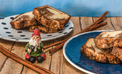 A gnome signals for quiet in front of his cinnamon bread.
