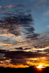 Beautiful sunset, sky with clouds of golden colors during the fall of the sun.