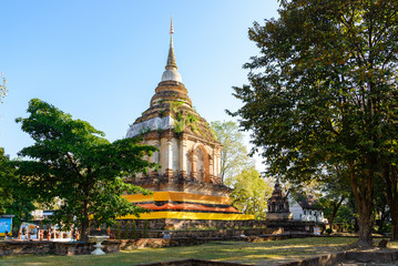 Fototapeta premium Outdoor scenery sunshine atmosphere of famous historical temple, Wat Jed Yod, and brick ruin pagoda and buddhist relief sculpture in Chiang Mai, Thailand.