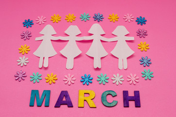 Paper doll chain, colorful little flowers and march made from colorful wooden letters on pink background