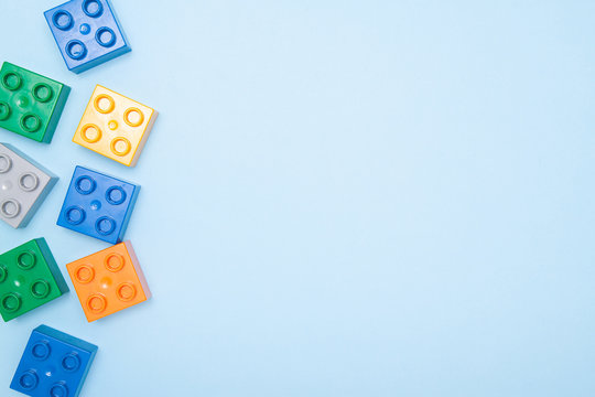 Baby kids toy frame. Top view multicolor cubes bricks on blue background. Blocks flat lay. Copy spase for text.