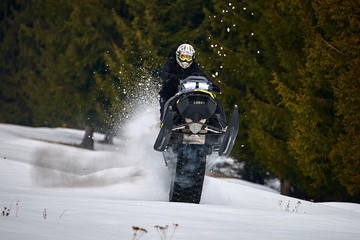 TUSNAD, ROMANIA - 02 February 2019: A man is riding snowmobile in mountains,Man driving snowmobile in TUSNAD, ROMANIA
