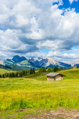 Italy, Alpe di Siusi, Seiser Alm with Sassolungo Langkofel Dolomite, an old barn in a field