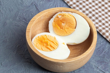 close up of half boiled eggs on wooden bowl
