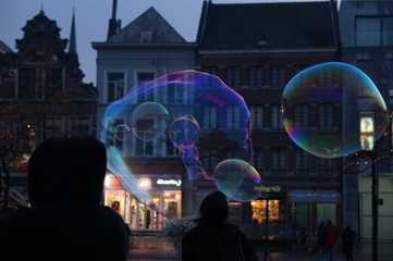 crowd of people at night in city playing with bubbles