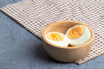 close up of half boiled eggs on wooden bowl