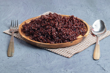 close up riceberry rice on wooden plate