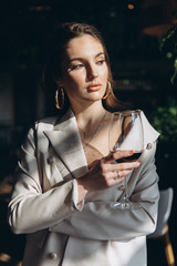 Elegant and glamour woman with glass of red wine in restaurant.