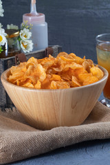close up of Crispy potato chips on wooden bowl