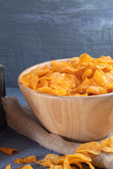 close up of Crispy potato chips on wooden bowl