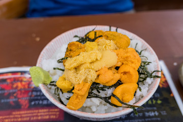 Close up shot of raw uni sashimi with seaweed and rice