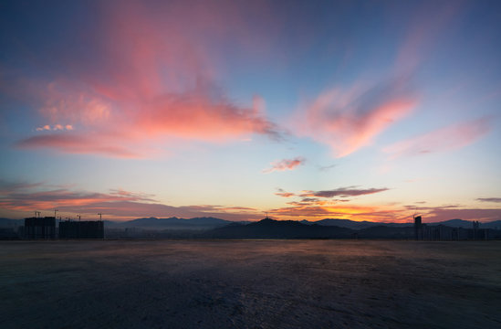 Empty Concrete Cement Floor With Dramatic Sunrise Purple And Pink Sky .