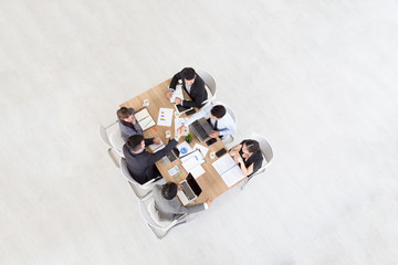 Top view of businessmen shaking hands sitting at conference table during team meeting, Entrepreneurs handshaking making deal starting collaboration at group negotiations teamwork with blank copy space