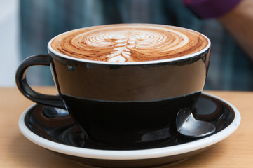 Close up of coffee cup with cappuccino coffee and milk froth on top