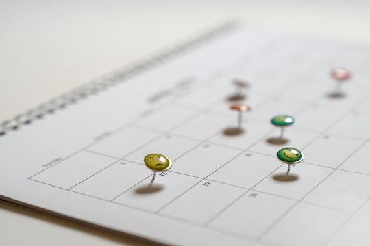 Business concept: thumbtack in calendar as reminders for meetings and appointments