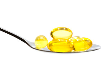 macro fish oil vitamins on spoon on white background.