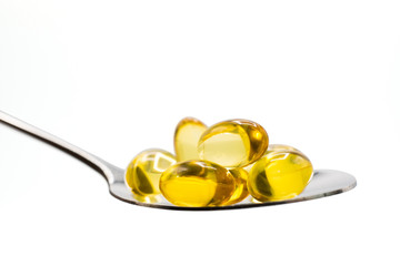 fish oil vitamins on spoon on white background with clipping path.