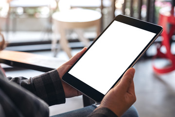 Mockup image of woman's hands holding black tablet pc with blank screen in cafe