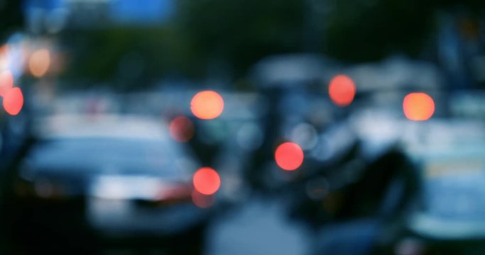 Defocused, blurred bokeh and abstract blurred light of car on street. Royalty high-quality free stock video footage of traffic light, glowing backdrop overlay for design. Traffic light in city night