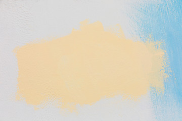 Textured putty on the wall with a yellow patch in the middle. Rough wall grunge background.