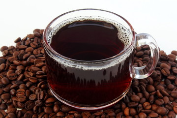 dark roasted coffee beans with coffee cup closeup on white background top view 
