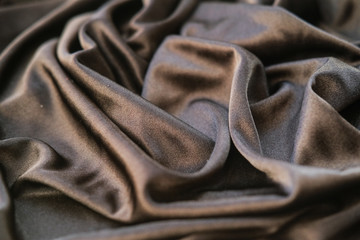 Fabric gold waves - material for background and texture. Close up black fabric.