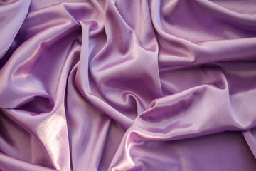 Close up pink fabric. The purple fabric is laid out waves. Fuchsia sateen fabric for background or texture.