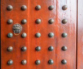 Red wooden door with lion's head door buckle