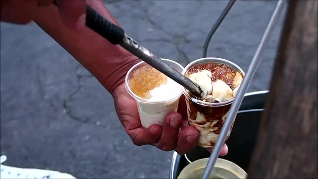 Handheld video shot of Filipino delicacy called Taho or soy bean curd being scoop by a vendor