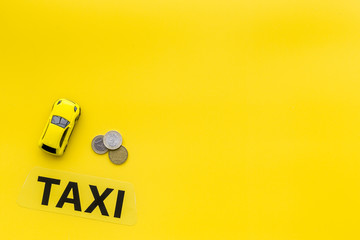 Taxi operator concept. Chip service. Sign taxi ner car toy and coins on yellow background top view copy space - obrazy, fototapety, plakaty