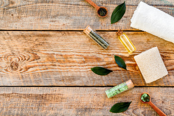 Tea tree spa composition. Fresh tea tree leaves, natural cosmetics, towel on rustic wooden background top view copy space border