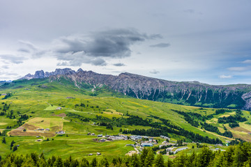 Alpe di Siusi, Seiser Alm with Sassolungo Langkofel Dolomite, a large green field with a mountain in the background
