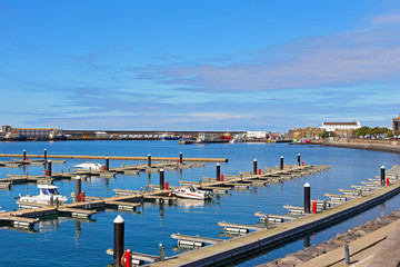 Fototapeta na wymiar Ocean port and motorboat piers of Ponta Delgada, Azores, Portugal. Moored vessels and motorboats at port piers on a beautiful sunny morning.
