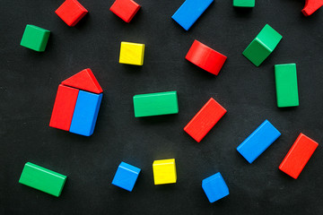 Children background. Wooden building blocks for developing and entertainment on black background top view