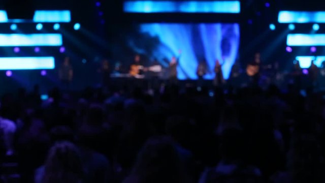 Blurry concert, rock , worship night, LED wall, people singing 