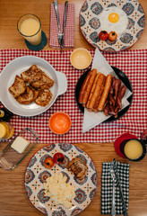Home style breakfast with crispy bacon, eggs, french toast, sausage and orange juice