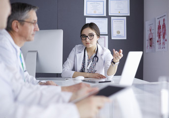 Serious medical team using a laptop in a bright office