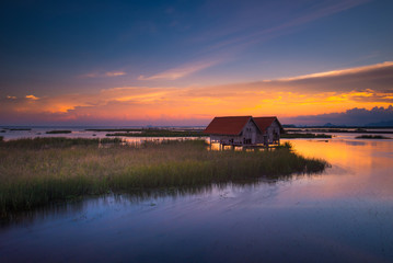 Old twin wooden houses at Thale Noi with nice sky sunset, Phatthalung province in Thailand.