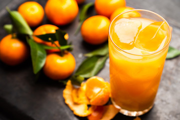 Fresh beverage with mandarines on the rustic background. Selective focus. Shallow depth of field.