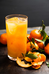 Fresh beverage with mandarines on the rustic background. Selective focus. Shallow depth of field.