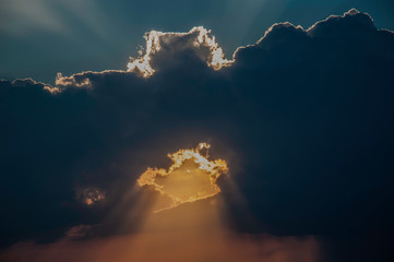 Promienie słońca przechodzące przez ciemne burzowe chmury © Bea