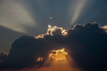 Promienie słońca przechodzące przez ciemne burzowe chmury © Bea