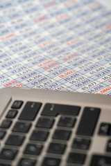 laptop keyboard with spreadsheet in the background