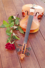 Fototapeta premium Violin and red rose on a wooden table