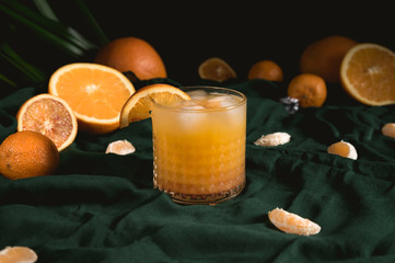 Fresh orange juice with fruits on green background